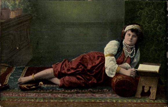 Postcard Türkiye, Turkish woman reading, lying on a carpet