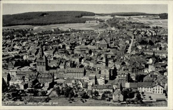 Ak Völklingen im Saarland,  Luftansicht, Stadtansicht, Häuser, Kirche, Wald im Hintergrund