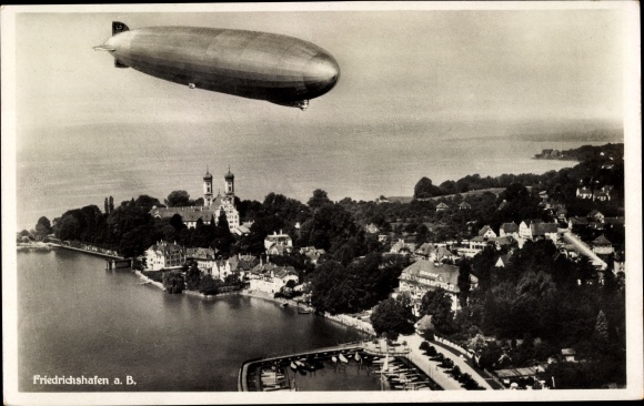 Ak Friedrichshafen am Bodensee, Luftschiff LZ 127 Graf Zeppelin über der Stadt, Fliegeraufnahme