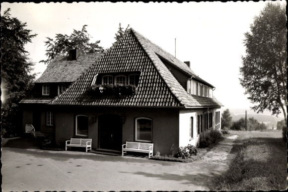 Ak Ostercappeln in Niedersachsen, Haus mit Satteldach, Bänke vor dem Eingang, Bäume im Hintergrun