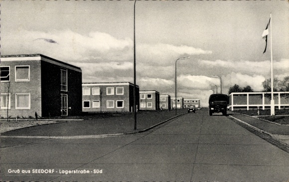 Postcard Seedorf in the district of Segeberg, modern residential buildings, Lagerstraße, cloudy sky, car in the foreground...