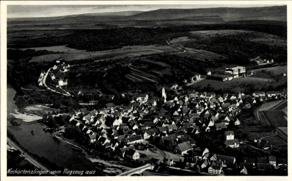 Ak Neckartenzlingen Baden Württemberg, Luftaufnahme von  Blick auf die Stadt, Fluss im Vordergrun