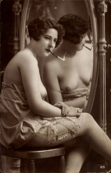 Photo Postcard woman in slip in front of the mirror, bare-breasted, cigarette with cigarette holder