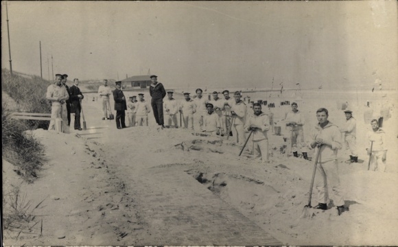 foto Ak Wangerooge, rekruten van de Marine Artillerie Divisie, scheppen zand op de strandwal, 1914