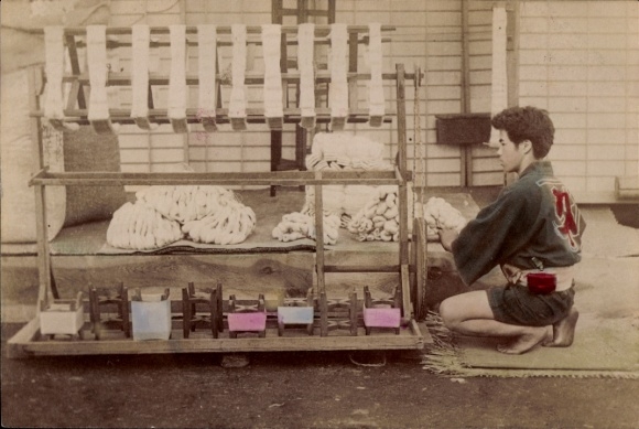 Foto Japan, Junger Mann bei der Arbeit an einem Spinnrad, coloriert