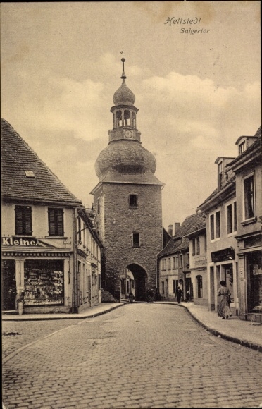 Ak Hettstedt im Südharz,  Saigeritor, steinerner Turm, gepflasterte Straße, Gebäude, Wolken