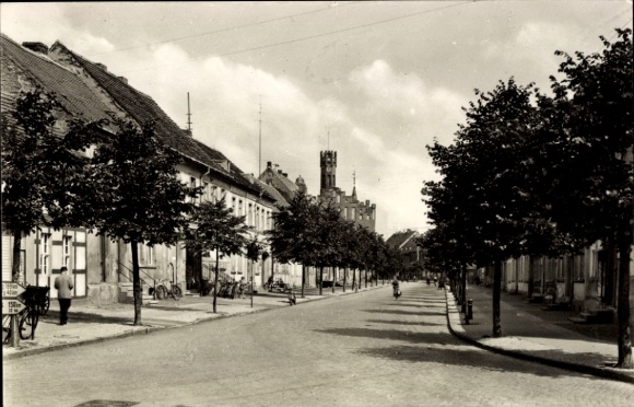 Postcard Kyritz in der Prignitz, street view with trees, houses, tower in the background
