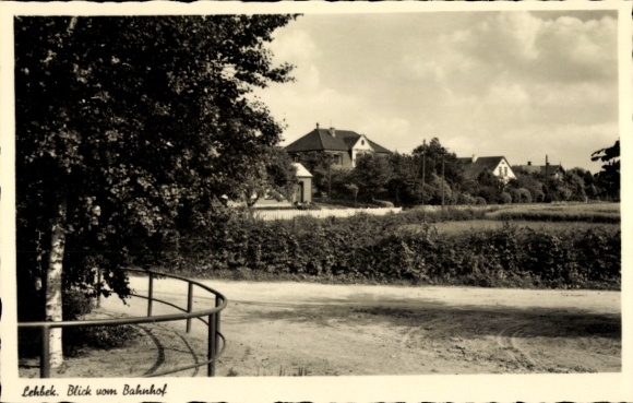 Ak Lehbek Gelting in Angeln, Vorderansicht eines Bahnhofs, Häuser im Hintergrund, Strasse und Bäu