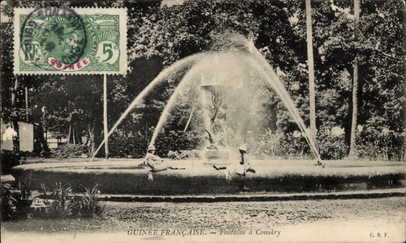 Ak Conakry Guinea, fontein met sproeiwater, bomen op de achtergrond, postzegel