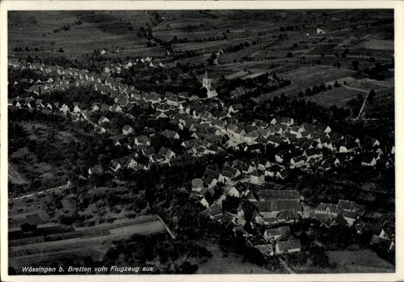 Ak Wössingen Walzbachtal in Baden, Luftaufnahme von Wössingen, Dorf mit vielen Dächern, Kirche si