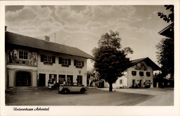 Postcard Unterwössen in Upper Bavaria, two buildings, pharmacy, car, tree, sky with clouds, b...