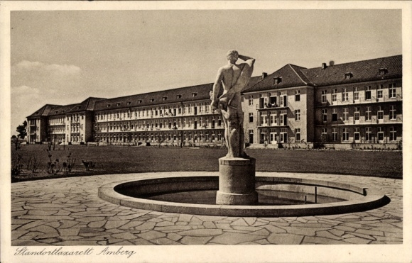 Ak Amberg in der Oberpfalz Bayern, Statue in einem Brunnen, Gebäude im Hintergrund, historisch...