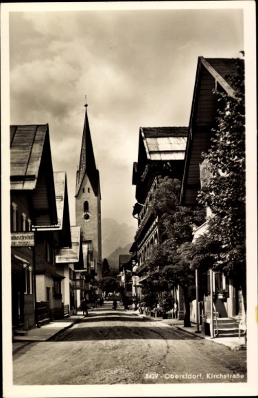Ak Oberstdorf im Oberallgäu, Straße mit Häusern, Kirche im Hintergrund,  Kirchstraße