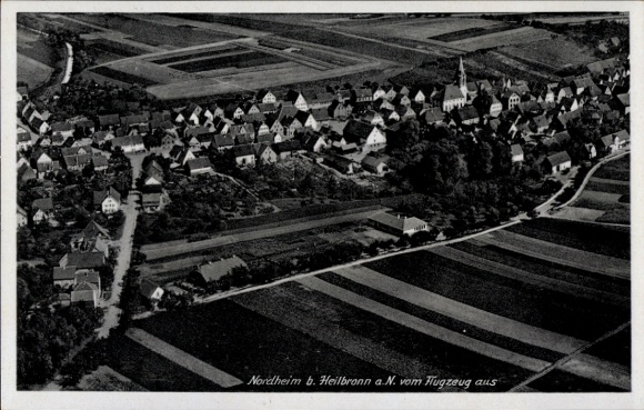 Postcard Nordheim am Neckar, aerial view of a village, typical German architecture, fields in the foreground
