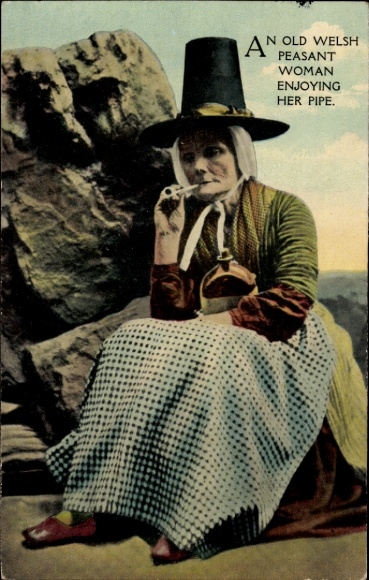 Postcard Wales, young woman in folk costume, pipe