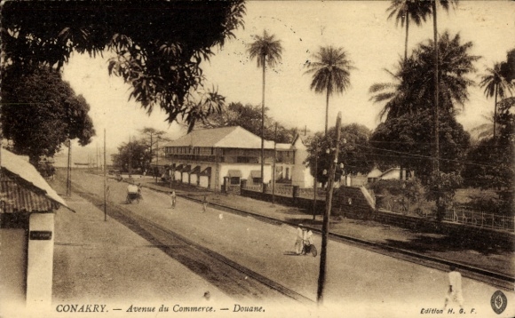 Ak Conakry Guinea, Avenue du Commerce, Douane, palmbomen, straatbeeld