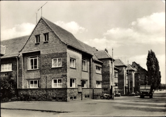Ak Teutschenthal im Saalekreis, Mehrere Ziegelbauten, Straßenansicht, Bäume, Himmel mit Wolken