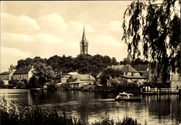 foto Feldberg in Mecklenburg, landschap met rivier, boot, huizen, kerk op de achtergrond