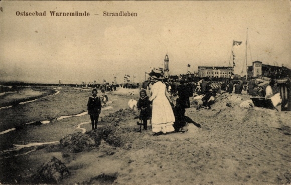 Postcard Ostseebad Warnemünde Rostock, beach with people, children at the water, huts, flags, buildings
