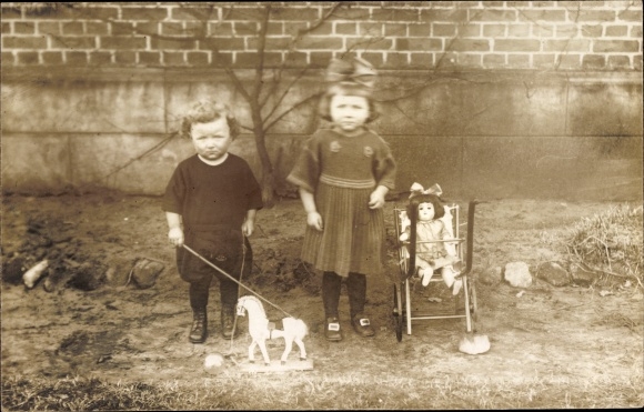 Photo Postcard Girl with doll in doll&#39;s pram, boy with wooden horse