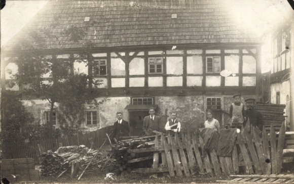 foto Brüderwiese Deutscheinsiedel in het Ertsgebergte, oud vakwerkhuis, mensen, houtstapel