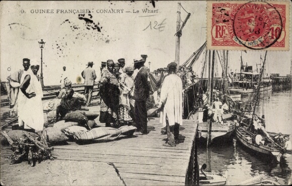 Ak Conakry Guinea, toegangsgebied met mensen, goederen op de pier, boten in het water