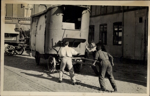 Foto Ak Männer schieben ein Fahrzeug, Kutsche, Pkw-Anhänger