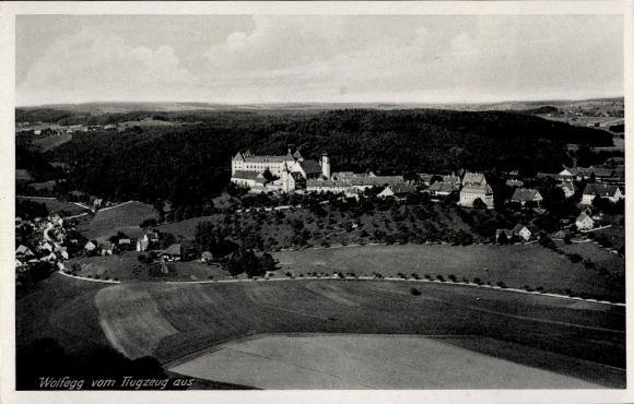 Ak Wolfegg im Allgäu, Luftaufnahme von  Gebäude und Landschaft, Wolken am Himmel