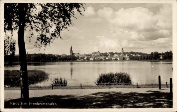 KP Nässjö Szwecja, widok na promenadę plażową, wodę, drzewa, chmury