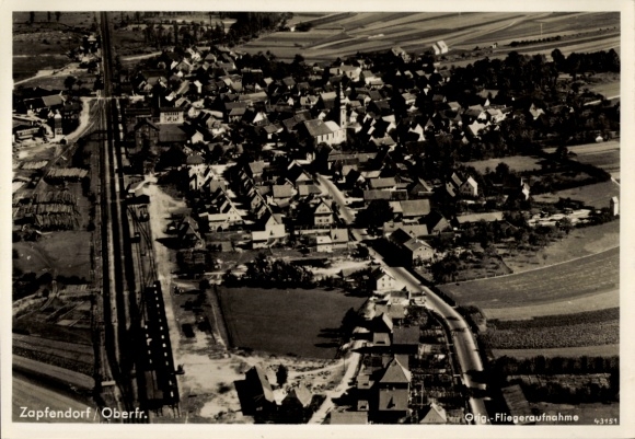 Ak Zapfendorf in Oberfranken, Luftaufnahme von  viele Häuser, Kirche, Eisenbahnlinie