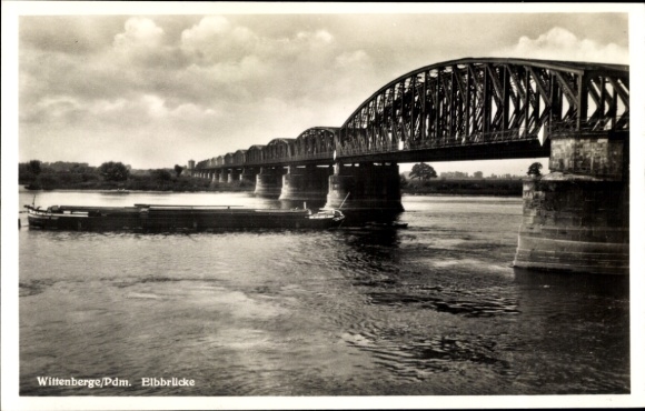 Postcard Wittenberge on the Elbe Prignitz, old steel bridge over the river, ship on the shore, cloudy sky