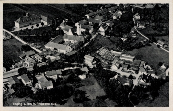 Ak Töging am Inn Oberbayern, Luftaufnahme der Stadt, mehrere Gebäude, ländliche Umgebung, Flugzeu