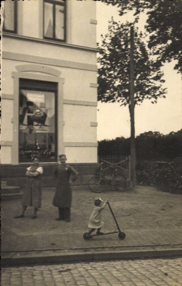 Foto Ak Kirchweyhe Weyhe Niedersachsen, Geschäftshaus, Schaufenster, Anwohner, Kind mit Roller