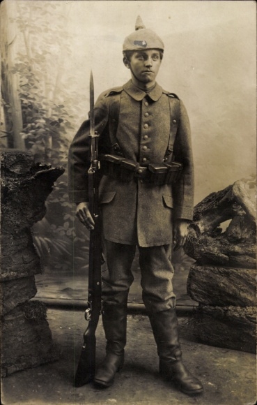 Photo Postcard German soldier in uniform, spiked helmet, bayonet, standing portrait