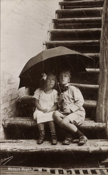 Postcard Children sit under an umbrella, rainy weather