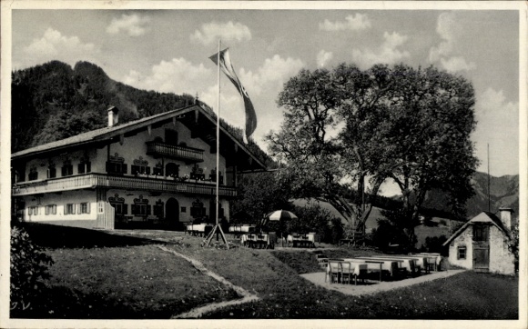 Postcard Ruhpolding in Upper Bavaria, mountain café, vineyard, building with flag, outdoor tables, nature