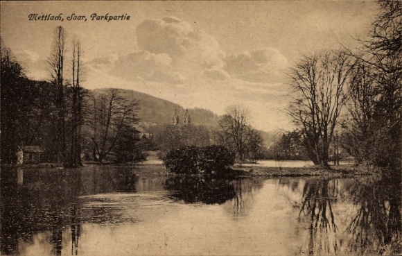 Postcard Mettlach in Saarland, park landscape on the banks of the Saar, water, trees, buildings in the background