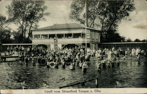 Ak Torgau an der Elbe, Strandbad  viele Menschen im Wasser, Gebäude im Hintergrund, Flagge