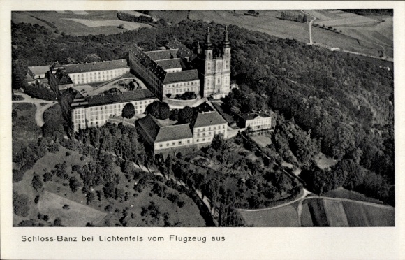 Ak Lichtenfels am Main Oberfranken, Schloss Banz, Luftaufnahme, umgeben von Bäumen und Feldern