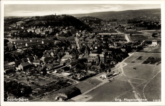 Postcard Saarbrücken in Saarland, aerial view of many buildings, green landscape