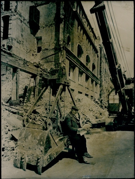 Foto Berlin, Kriegszerstörung 2. WK, Mann liest zwischen Ruinen Zeitung, Greifer einer Baumaschine