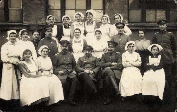 Photo Postcard German soldiers in uniform, group photo with nurses, hospital
