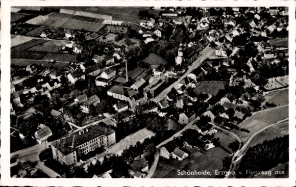 Ak Schönheide im Erzgebirge Sachsen, Luftbild von  Erzgebirge, viele Häuser, Kirche, Ferienfeld