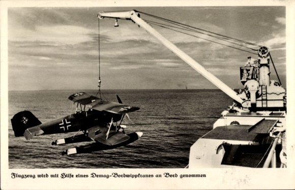 Postcard Heinkel He 60c fighter plane is taken on board, Demag on-board luffing crane, Luftwaffe, Kriegsmarine