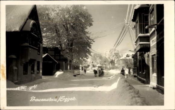 Ak Frauenstein im Erzgebirge, Winterlandschaft, schneebedeckte Straße,  Gebäude, Pferdeschlitten