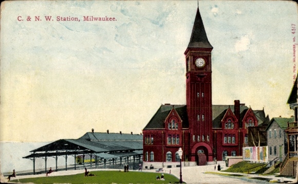 Ak Milwaukee Wisconsin USA, C. & NW Station, rood gebouw met klokkentoren, groene weide, water...