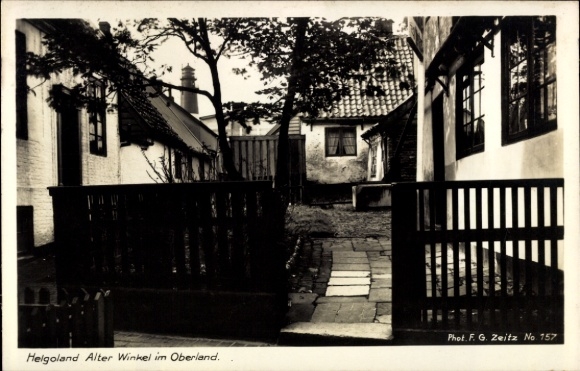 Ak Nordseeinsel Helgoland, Schmale Gasse, alte Häuser, Bäume, Pflastersteine, Helgoland