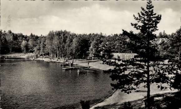 Ak Bad Liebenwerda in Brandenburg, See mit Badebereich, Bäume, Wolken, Gebäude im Hintergrund