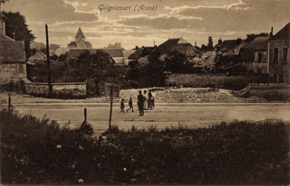 Ak Guignicourt Aisne, landschap met huizen, mensen op straat, kerk op de achtergrond