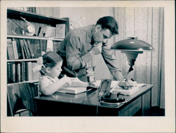 Photo of cosmonaut Vladimir Komarov with his daughter Irina, at the desk, 1964